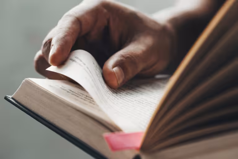 Hand blättert eine Buchseite um