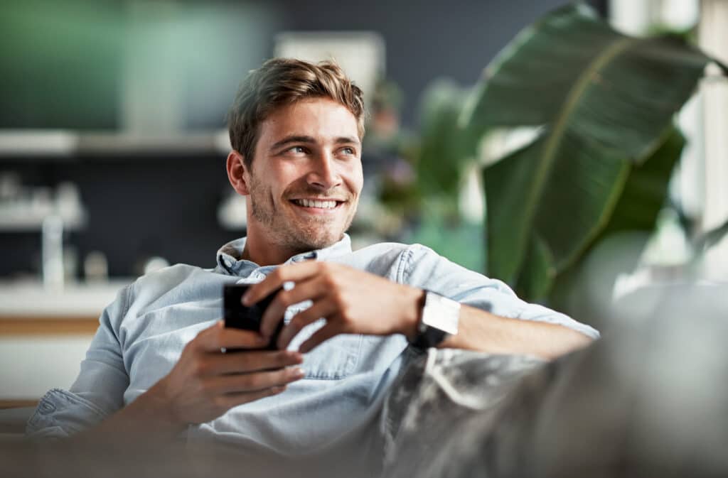 Mann mit Handy guckt über die Schulter