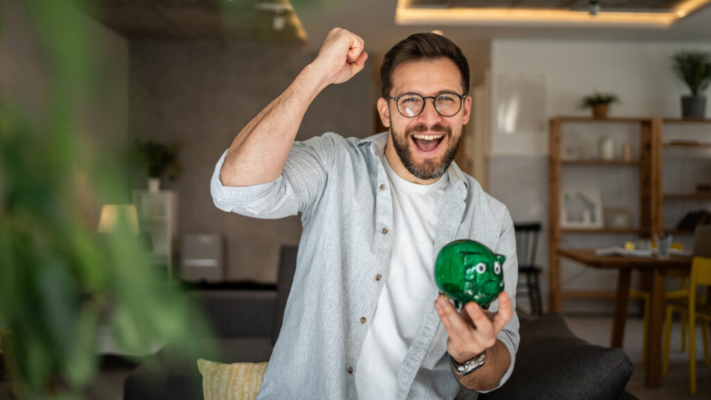 Mann mit Sparschwein freut sich
