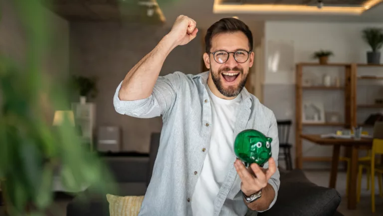 Mann mit Sparschwein freut sich