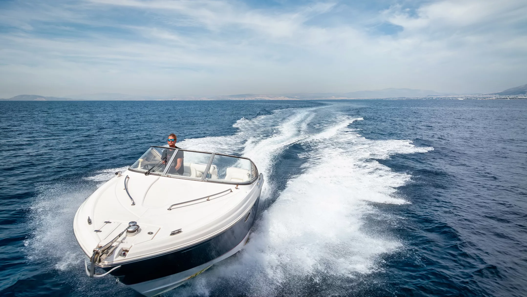 Mann fährt in einem Motorboot über das Meer