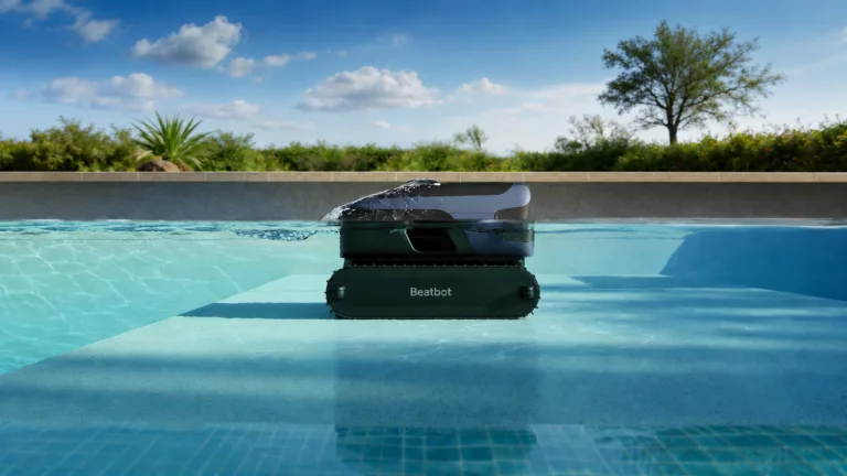 Querschnittsicht von einem Pool in dem ein dunkler Poolroboter von Beabto schwimmt, Pflanzen und blauer Himmel im Hintergrund