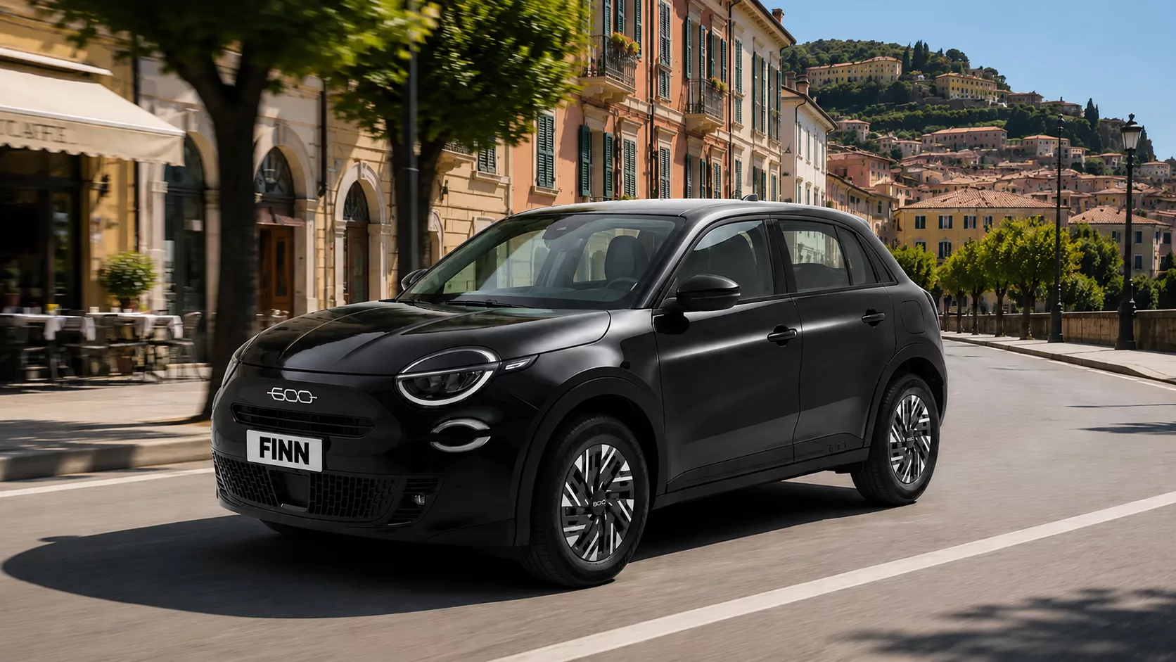 Schwarzer Fiat 600 auf Straße vor mediterraner Stadtkulisse