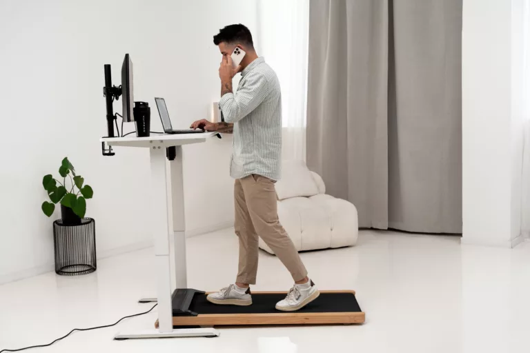 Mann läuft im Homeoffice am Stehschreibtisch auf dem Kuipers K1 Walking Pad.
