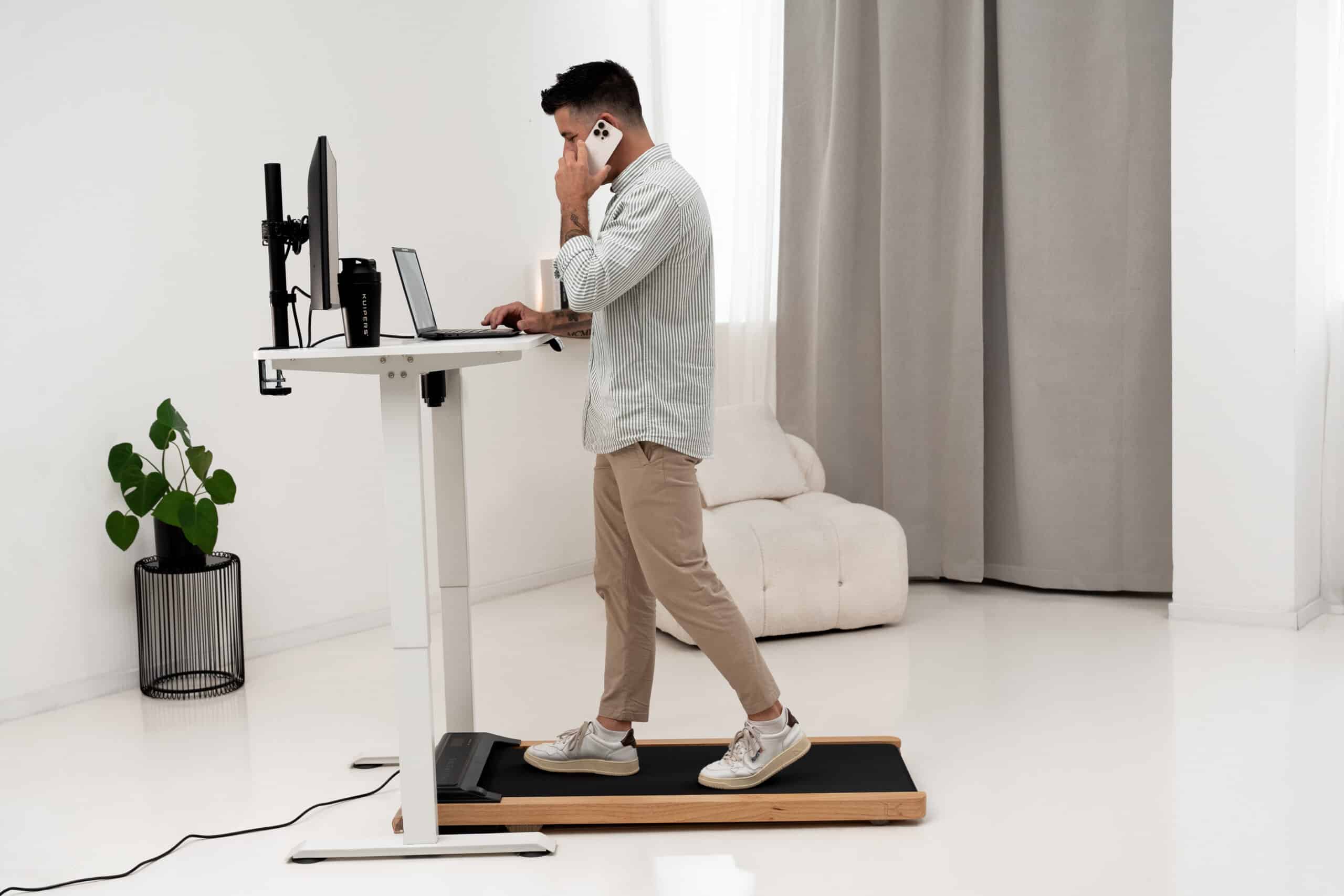 Mann läuft im Homeoffice am Stehschreibtisch auf dem Kuipers K1 Walking Pad.