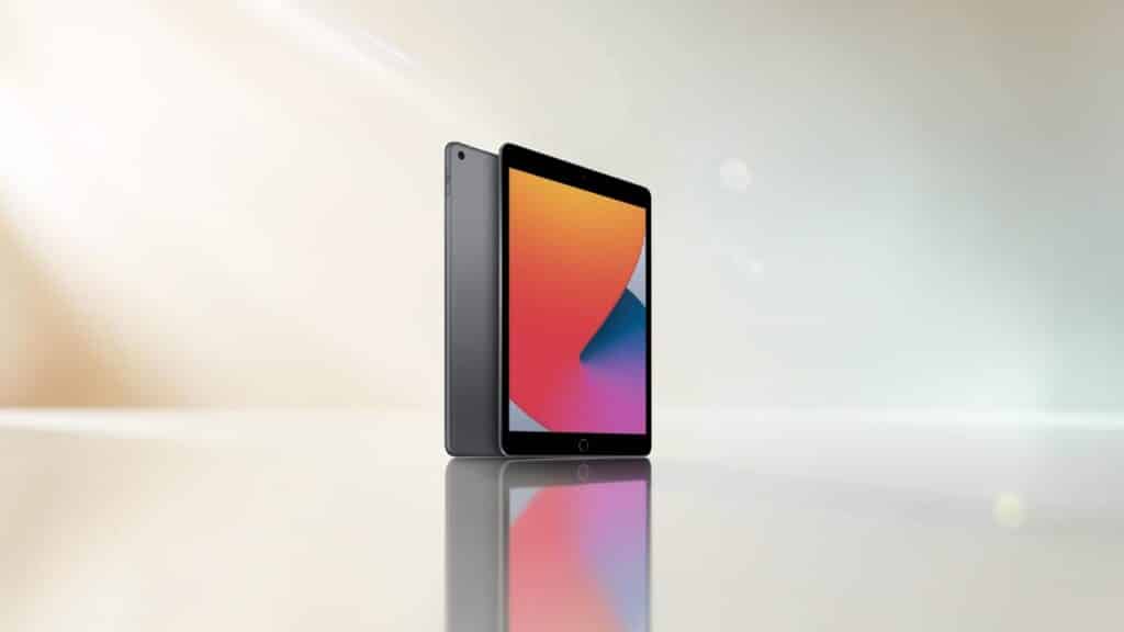 Graues Apple iPad Tablet schräg von der Seite von hinten und vorne mit bunten Farben auf Display auf einer spiegelnden Fläche gold blaugraue Farbverläufe und Lichtreflexionen im Hintergrund