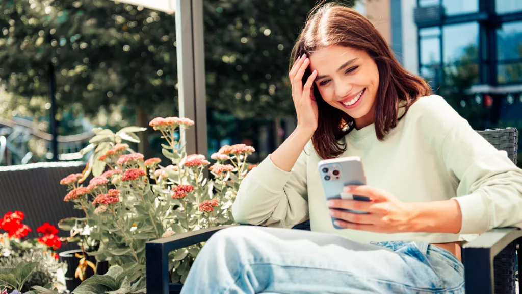 Junge Frau mit Smartphone lächelt