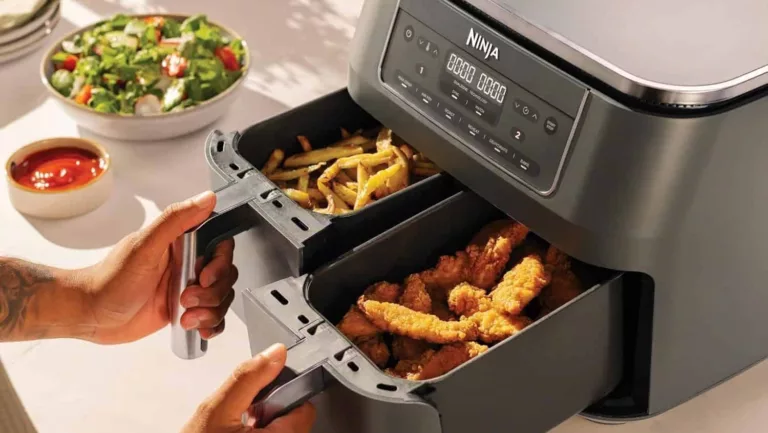 Zwei Hände ziehen die Fächer der Ninja Dual Zone heraus. In einem Fach sind Pommes, in dem anderen Chicken Stripes.