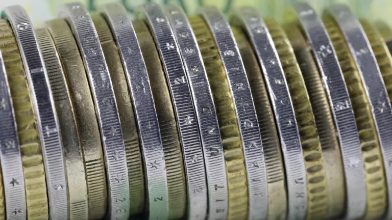 Münzen dicht aneinander auf 100 Euro Scheinen.
