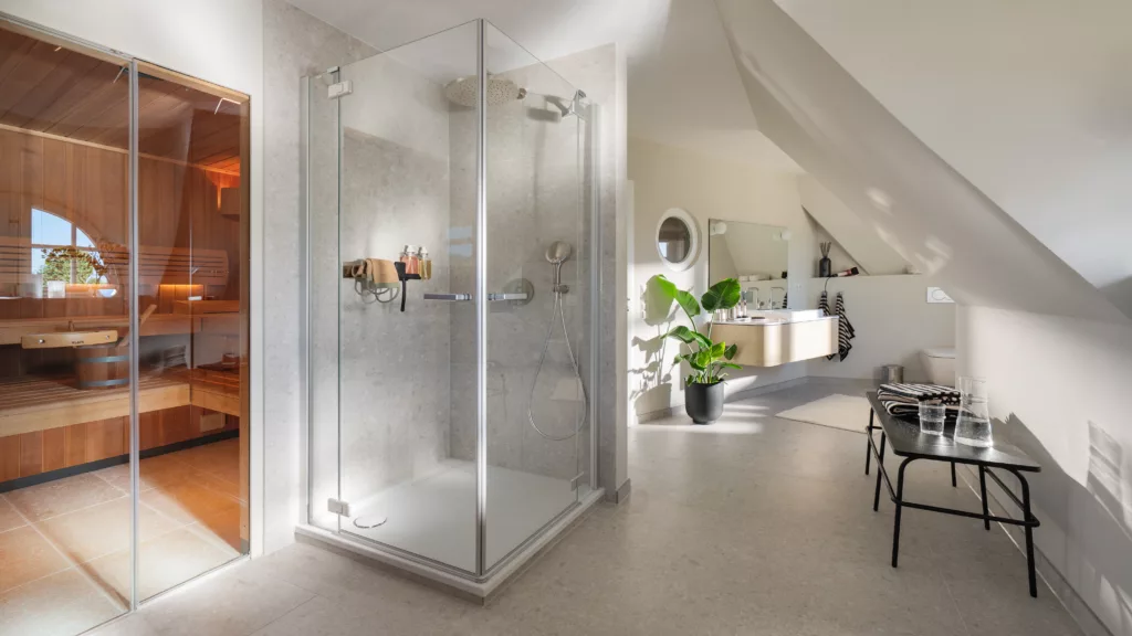 Helles Badezimmer mit Duschkabine, links Sauna