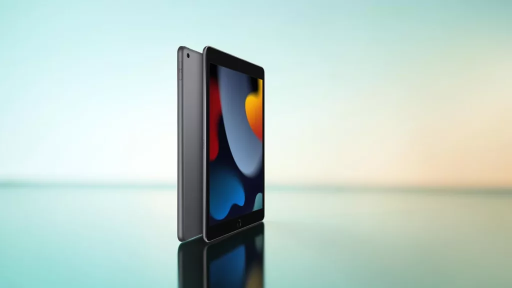 Graues Apple- iPad von hinten und vorne mit buntem Bildschirm vor hell türkisem Hintergrund mit spiegelndem Untergrund