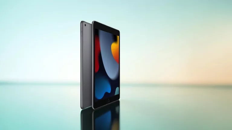 Graues Apple- iPad von hinten und vorne mit buntem Bildschirm vor hell türkisem Hintergrund mit spiegelndem Untergrund