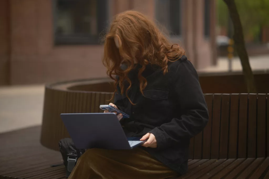 Frau mit Laptop und Handy