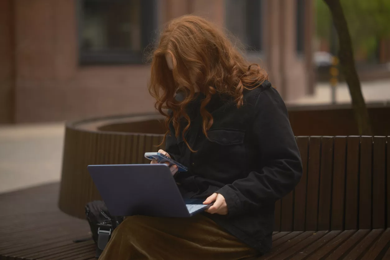 Frau mit Laptop und Handy