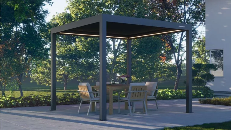 Schwarze Pergola mit warmleuchtenden Licht am Dachrand auf Holzterrasse wo Stühle drauf stehen, im Hintergrund Rasen und Bäume