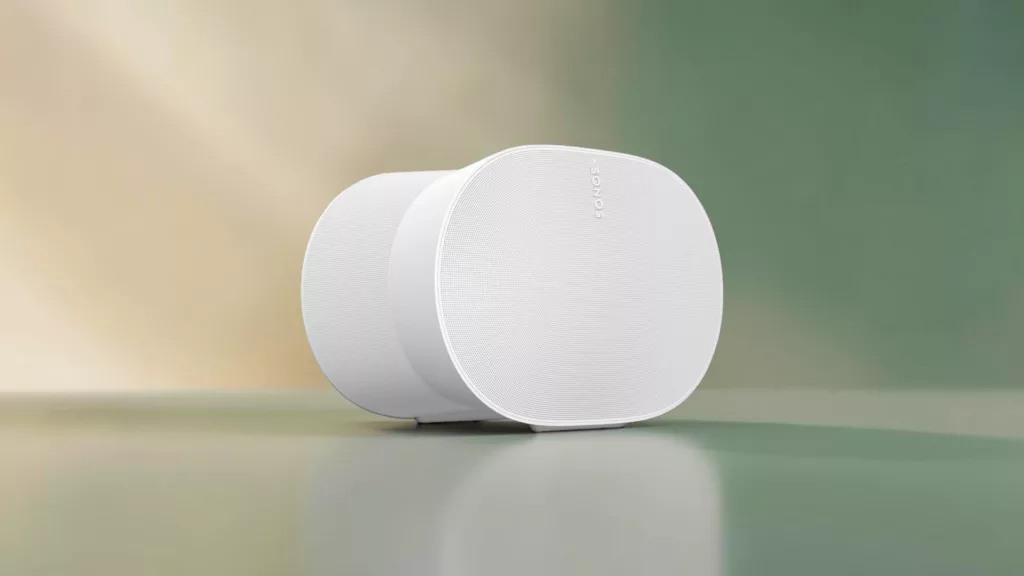 Weißer elliptischer Sonos Lautsprecher schräg von vorne auf spiegelnder Unterfläche mit Grün goldenem Hintergrund
