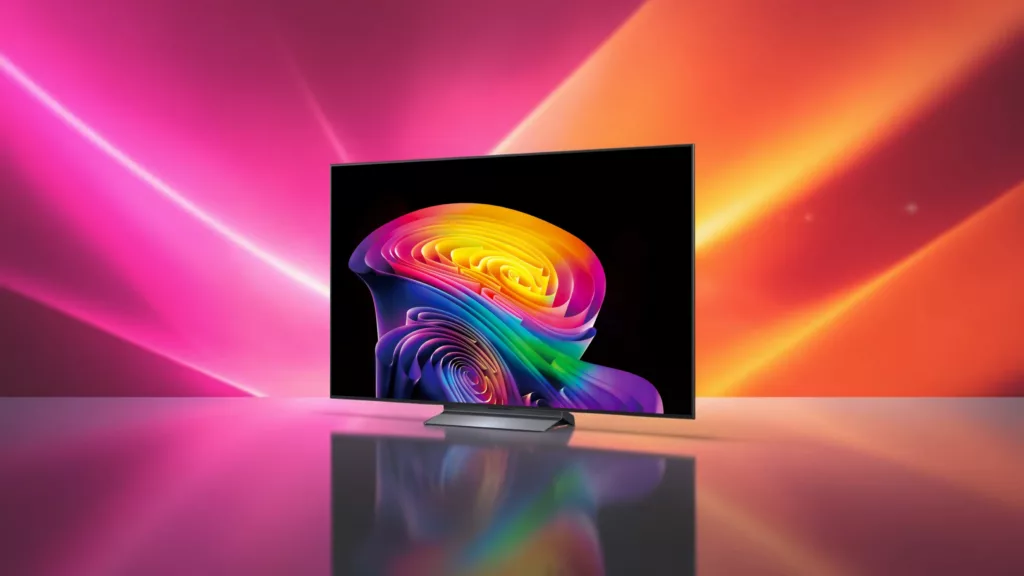 LG-Fernseher mit silbernem Standfuß schräg von vorne zeigt schwarzen Bildschirm mit einem bunten, knalligem Muster vor Pink orangenem Hintergrund mit Lichtstreifen auf spiegelnder Fläche