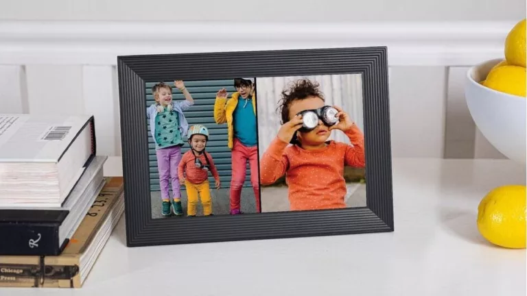 Schwarzer Bilderrahmen, der zwei hochkante Fotos von Kindern nebeneinander anzeigt, auf einer weißen Kommode mit Bücherstapel links und Zitronenschale rechts vor weißer Wand