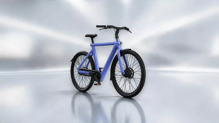 Lila blaues VanMoof-E-Bike schräg von vorne auf silbernem Hintergrund mit Schatten und Spiegelungen