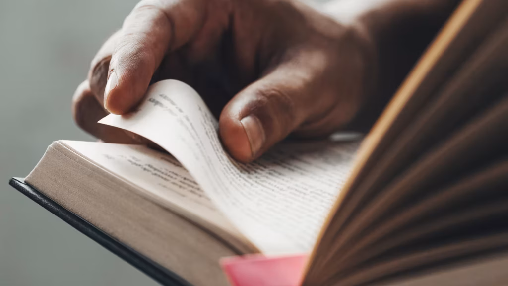 Hand blättert eine Buchseite um